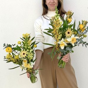 Woman holding Little Event Flowers in glass vases