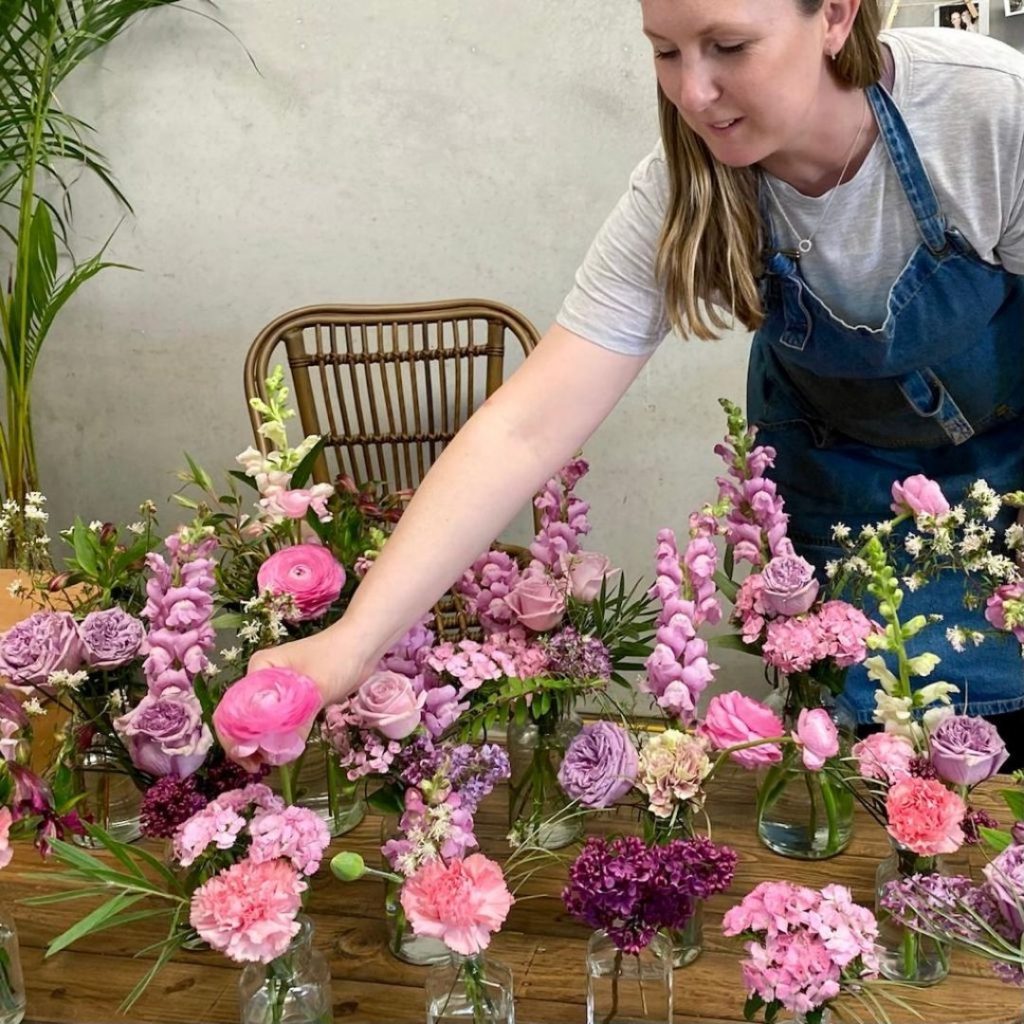 Florist arranging mixed seasonal blooms