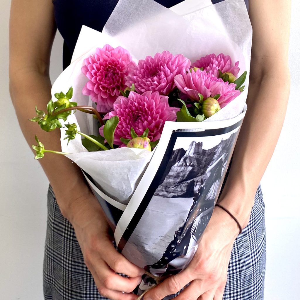 Bouquet wrapped in client-provided custom wrap for a branded corporate gift