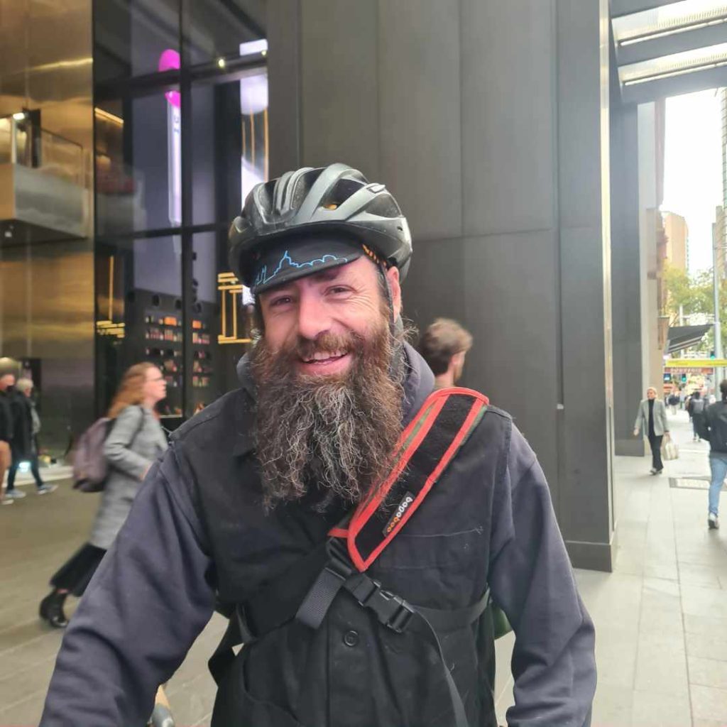 Bike courier in Sydney CBD wearing helmet and smiling